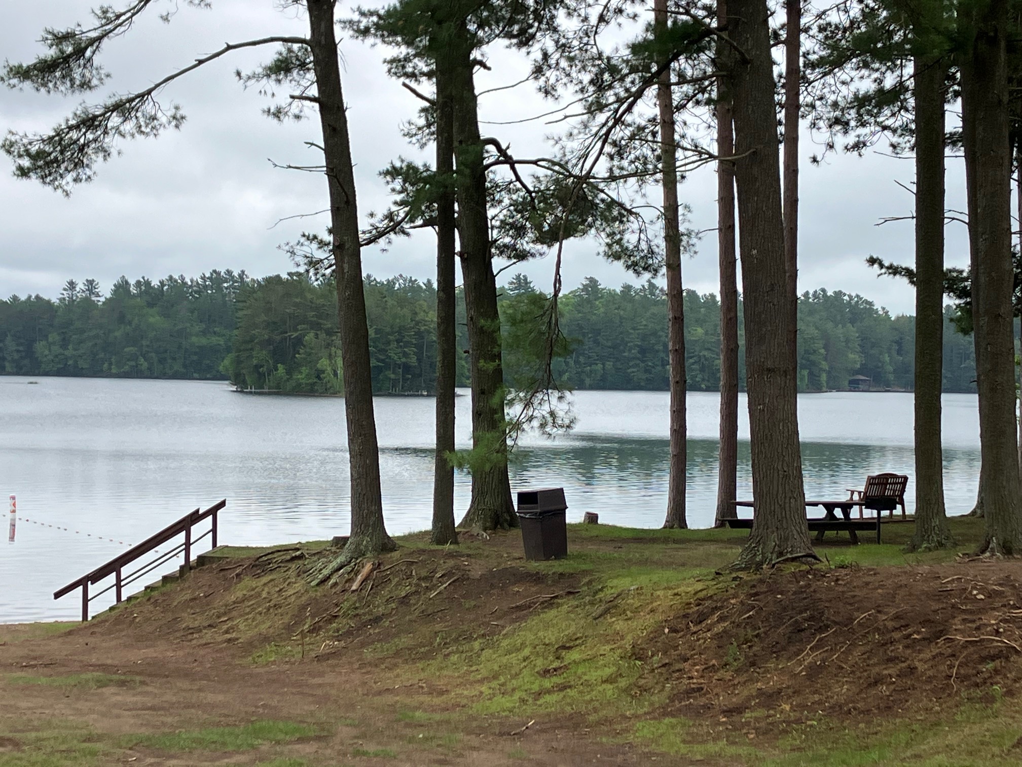Adirondack chairs facing a calm lake at a Hazelhurst resort