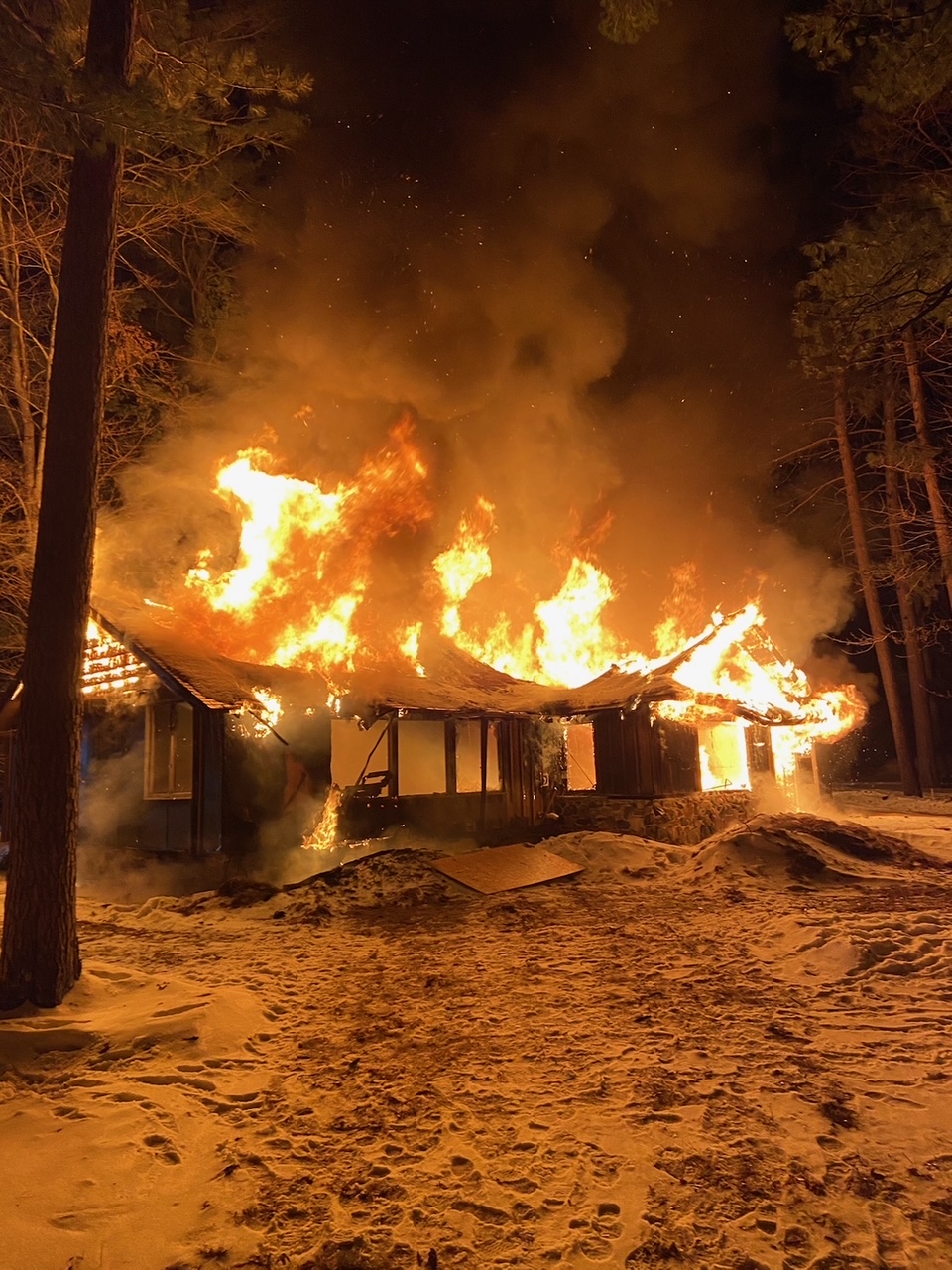 A structure burning at night during winter fire training