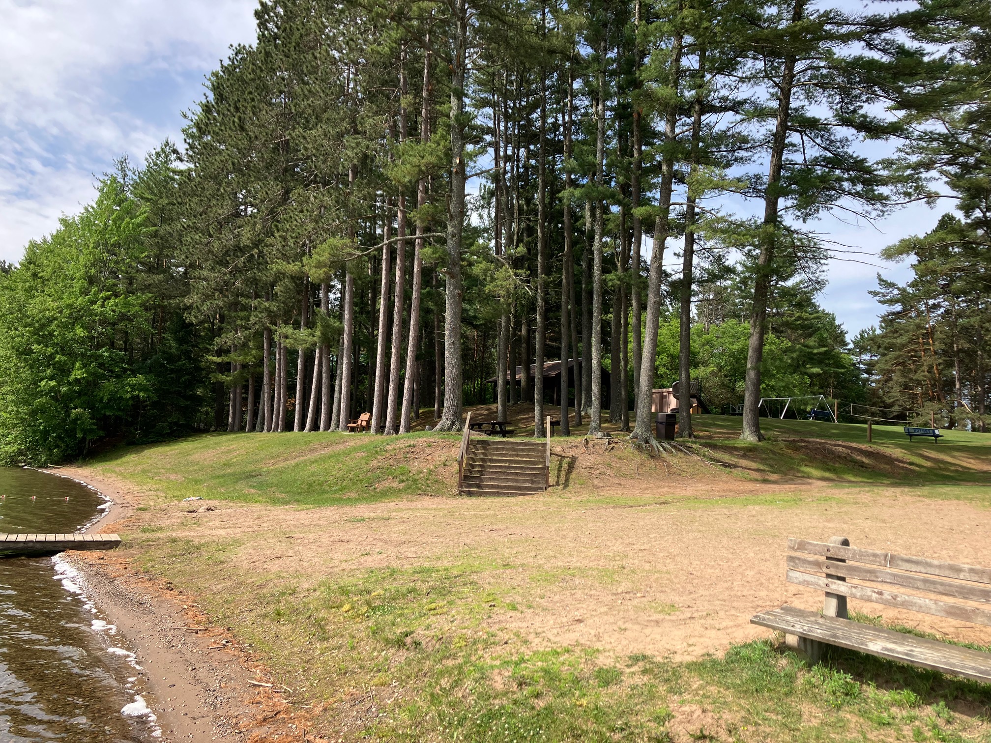 Wooden benches along the waterfront overlooking a peaceful Northwoods lake